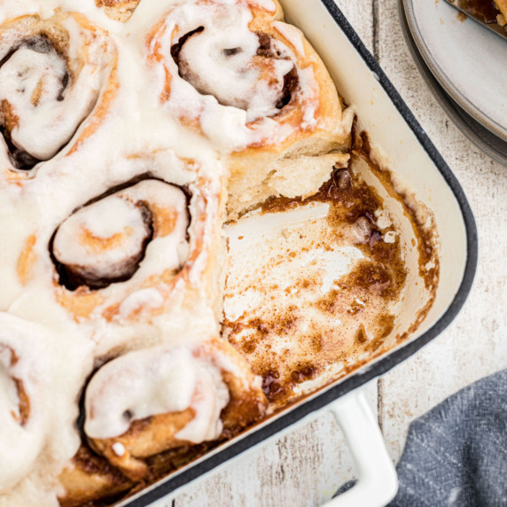 Overhead close up view of a pan of Amish Cinnamon Rolls with one missing.