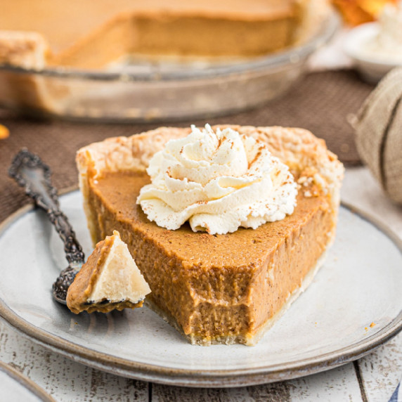 a slice of pumpkin pie with a little taken from the front