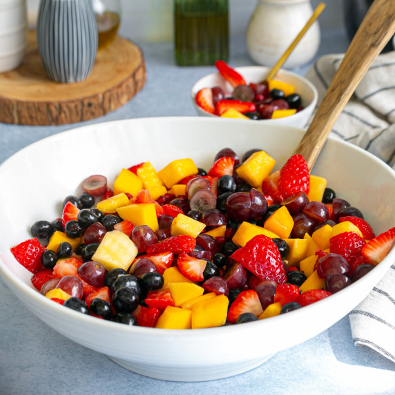 chopped red grapes, mango, blueberries and strawberries in a large white bowl