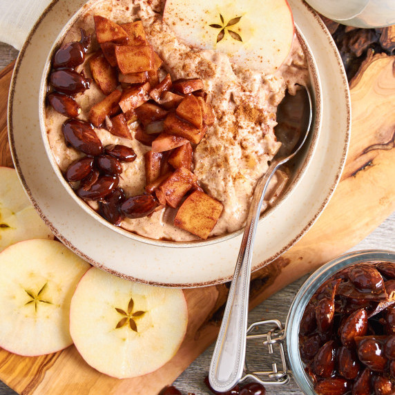 A bowl of Apple Cinnamon Protein Oatmeal topped with caramelized apples and almonds