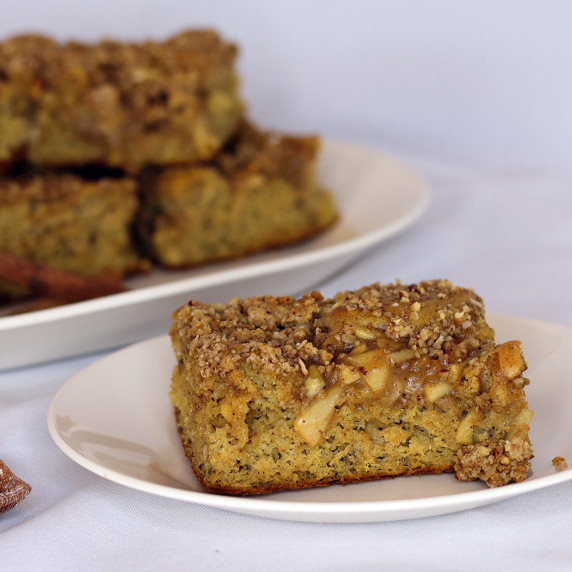 A piece of Apple Pie Sheet Pan Coffee Cake on a white plate against a white background