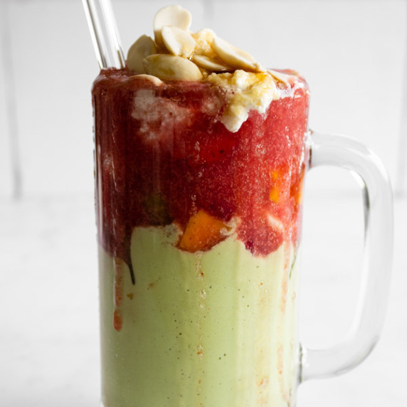 Lebanese avocado and strawberry cocktail with cream, almonds, and honey dripping on the side with a 
