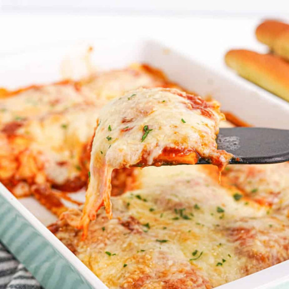 Ravioli casserole being served with a spatula from a baking dish.