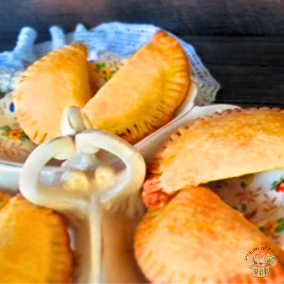 Baked Chicken Empanadas with ground chicken and peas on a white plate