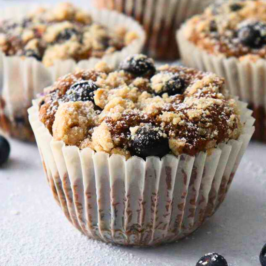 Delicious Bakery Style Blueberry Muffins with a golden streusel crumble and fresh berries.