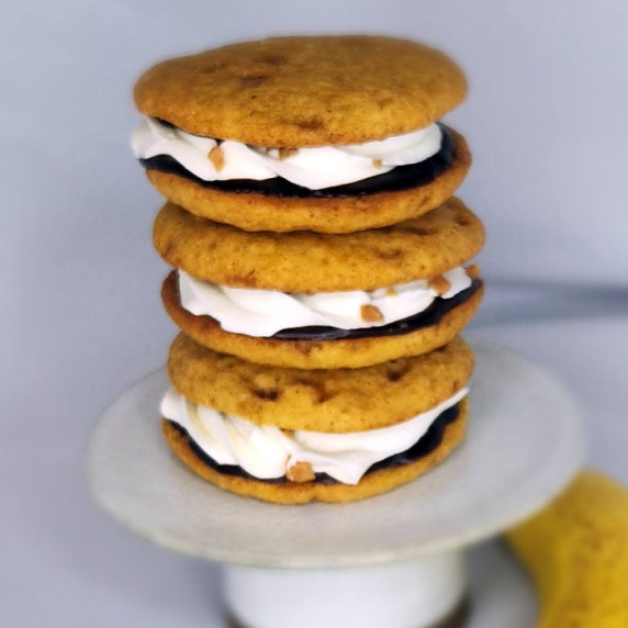 Banana Oat Whoopie Pies stacked on a small stand against a white background