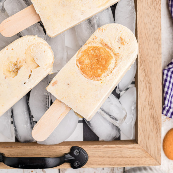 a couple of banana pudding popsicles laying on a tray full of ice