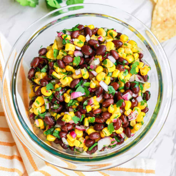 Black bean corn salsa overhead in a bowl with chips and cilantro.