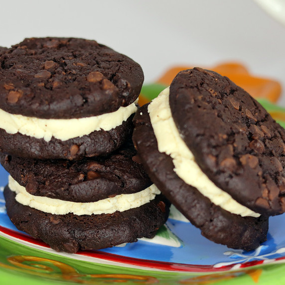 Black and white espresso sandwich cookies on a Christmas plate with white background