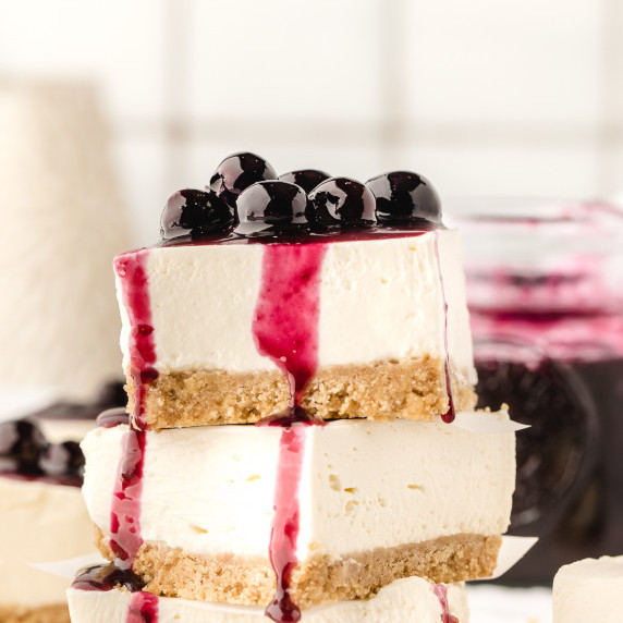 Stack of blueberry cheesecake bars.
