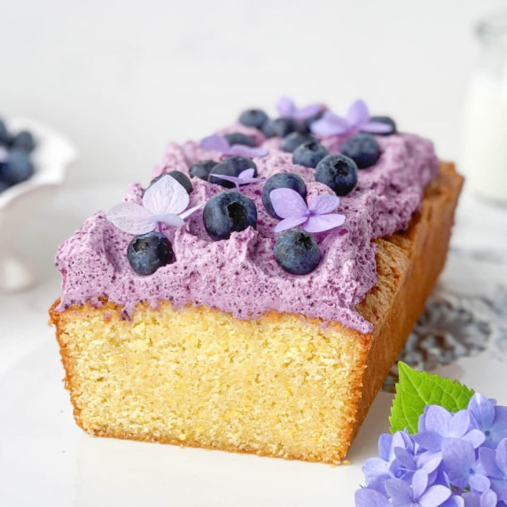 front view of sliced blueberry cornmeal pound cake on a white plate