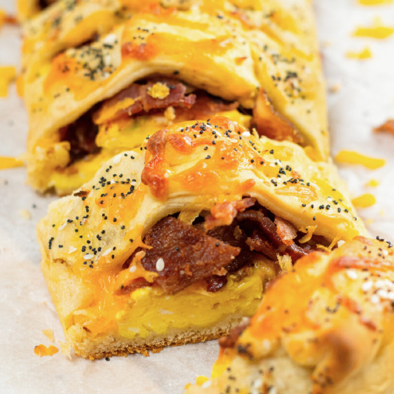Braid sliced to reveal an egg, bacon and cheese filling surrounded by a golden pastery