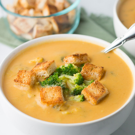 Broccoli Cheddar Soup garnished with croutons in a white bowl