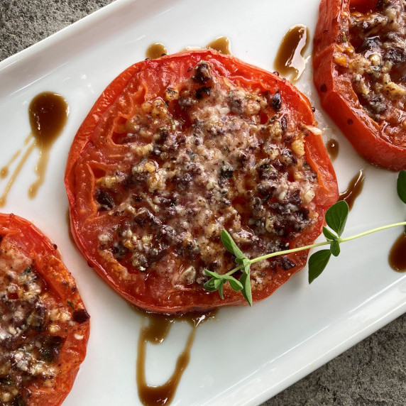 Broiled tomato slices topped with seasoned parmesan cheese and a balsamic glaze drizzle.