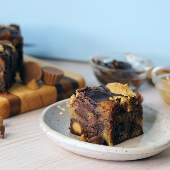 Peanut butter cup brookie on a plate with ingredients in the background