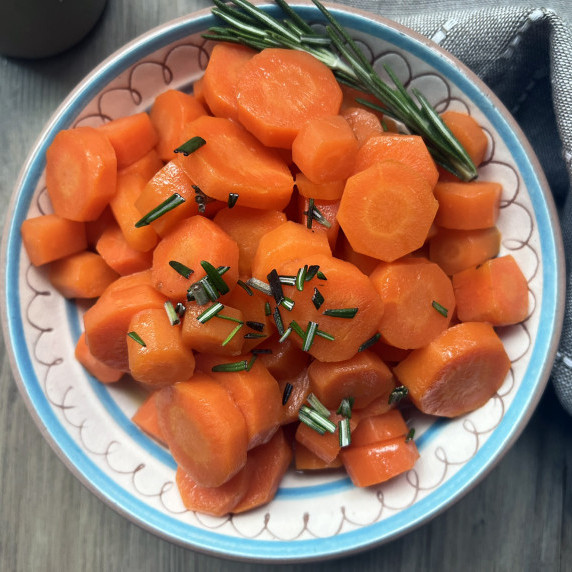 brown sugar boiled carrots in a small bowl with rosemary