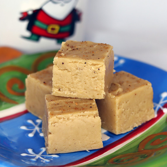 Brown sugar eggnog fudge arranged on a holiday plate against a white background.