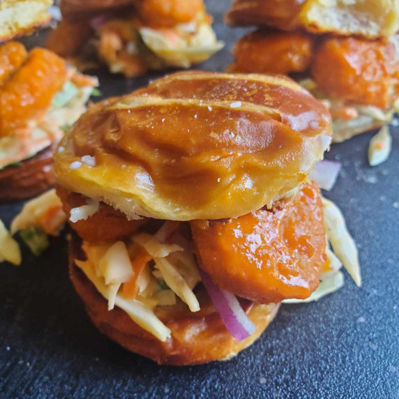 Golden pretzel buns stuffed with colourful slaw and saucy, red chik'n bites.