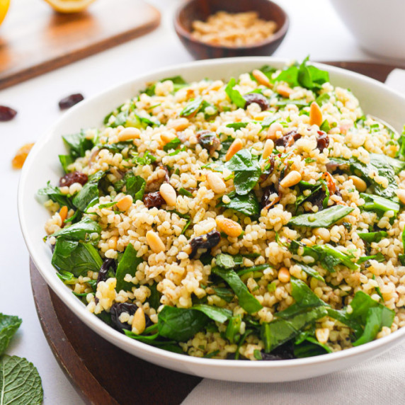 Bulgur Wheat Salad with Spinach, Pine Nuts & Raisins in a white bowl.