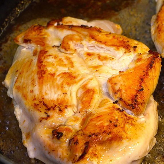 Roasted Chicken breast in a pan.