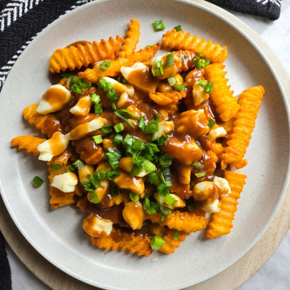 Golden crinkles topped with brown gravy, white curds, and green onions.