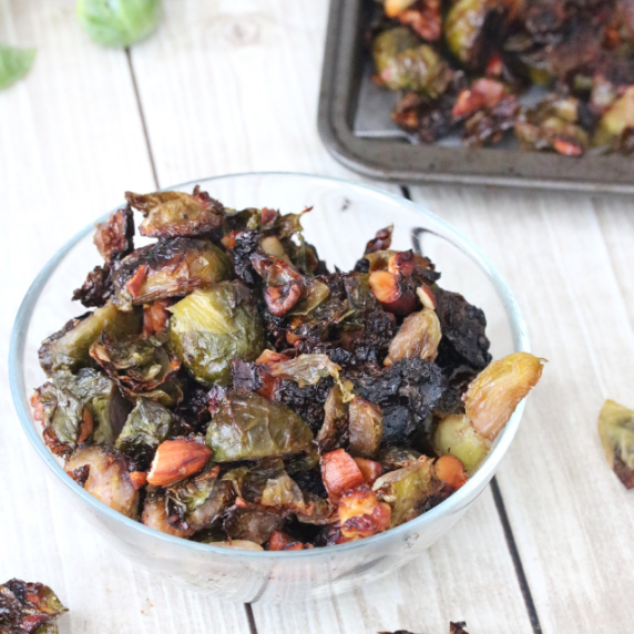 Glass bowl with crispy roasted Brussels sprouts.