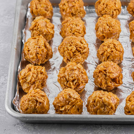 Caramel Cornflakes Treats Spheres on top of Aluminum foil cover baking tray