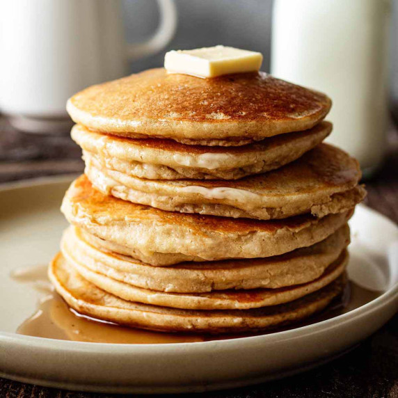Stack of cassava pancakes on an off white plate.