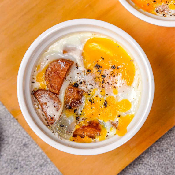 A white ramekin of oeufs en cocotte