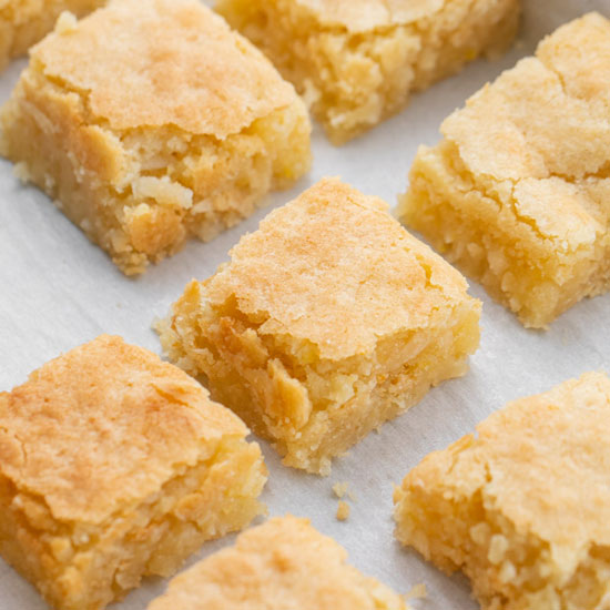 Chewy Coconut Bars in baking pan lined with parchment paper.