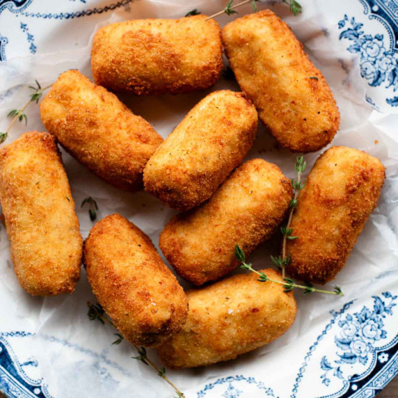 An overhead shot of chicken croquettes in a blue and white bowl