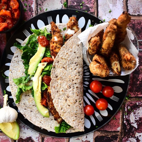Chicken goujons, lettuce and tomatoes inside a tortilla wrap