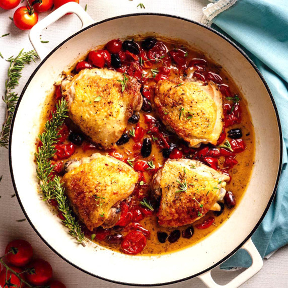 Chicken Provençal with crispy golden chicken thighs simmered in a skillet with tomatoes and olives