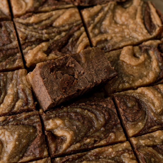 healthy black bean brownies in a pan with peanut butter swirled throughout 