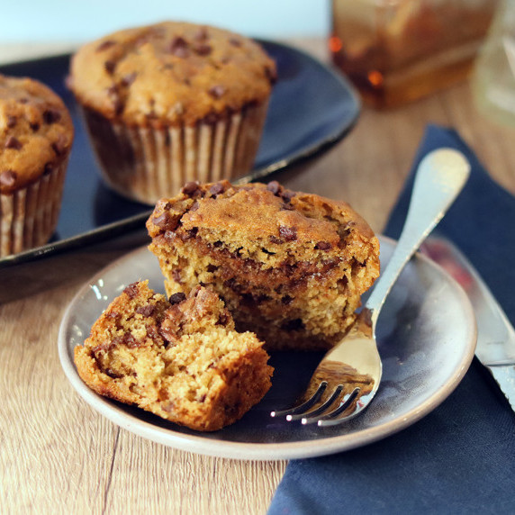 Chocolate banana peanut butter muffin broken open on a small blue plate.