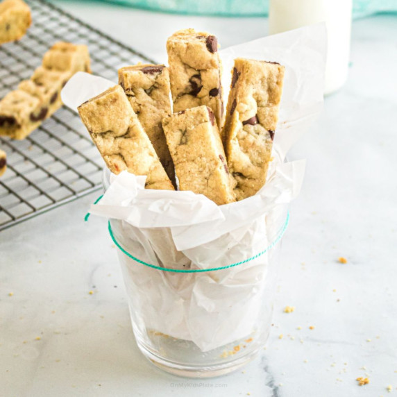 Chocolate cookie sticks served in a glass lined with parchment paper.
