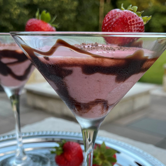 Strawberry smoothie cocktail with grated chocolate served in a chocolate syrup coated martini glass