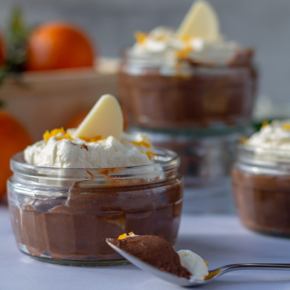 small pot of chocolatre orange mousse with a bite on a spoon