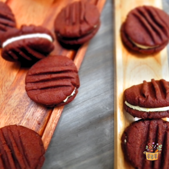 Chocolate sandwich cookies with orange buttercream on a wooden board