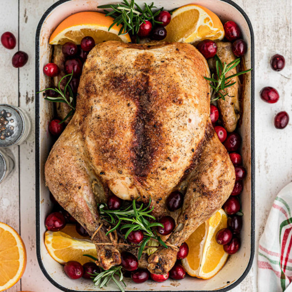 Overhead shot of a beautiful Christmas Roast Chicken with cranberries and oranges.