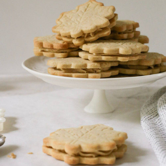 A stack of cinnamon sandwich cookies, shaped like maple leaves