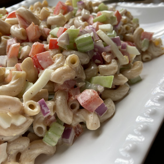 Elbow macaroni pasta salad in a white bowl.