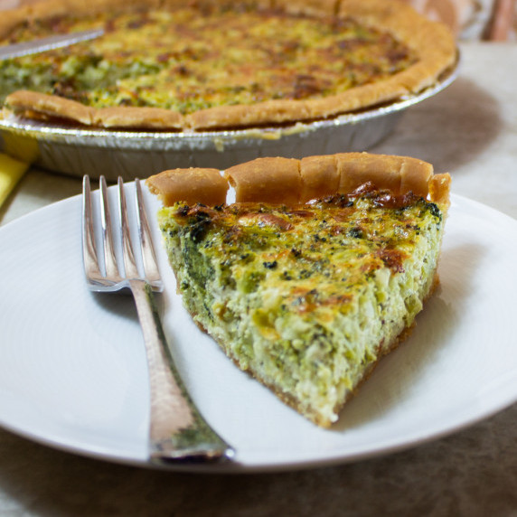 broccoli cheddar quiche on a plate with a fork