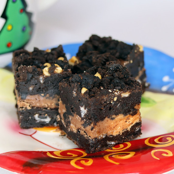 Three Triple Chocolate Cookies and Cream Brownies arranged on a Christmas plate.