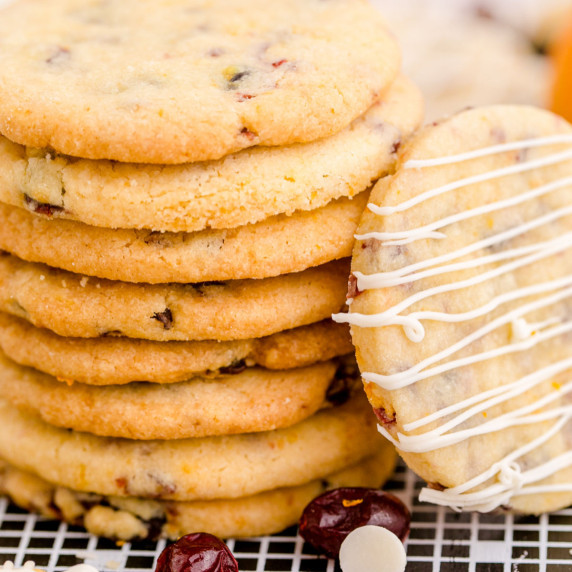 a stack of cranberry and orange shortbread cookies with one standing on the side