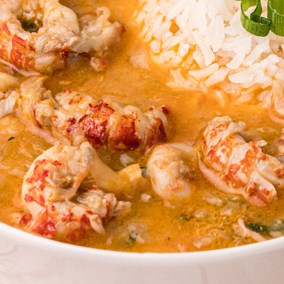crawfish tails in an etouffee sauce with rice in the background