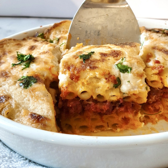 Bechamel Pasta Recipe in a large baking dish with a slice being cut out.
