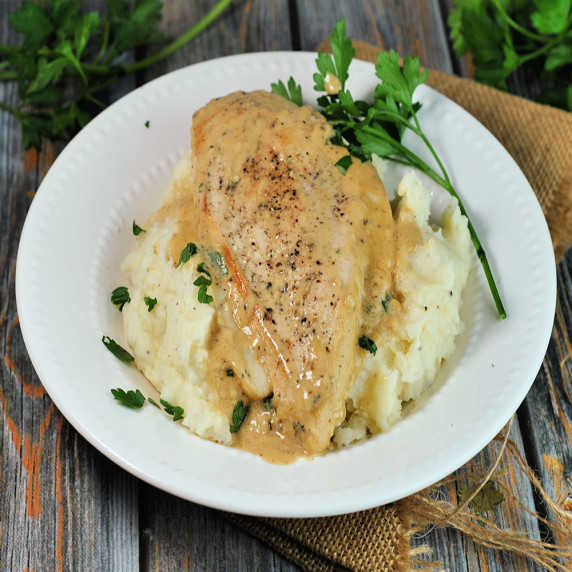 Creamy chicken fricassee served over mashed potatoes, garnished with parsley