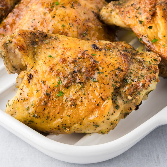 Golden-brown roasted ranch chicken thighs seasoned on a white serving platter.