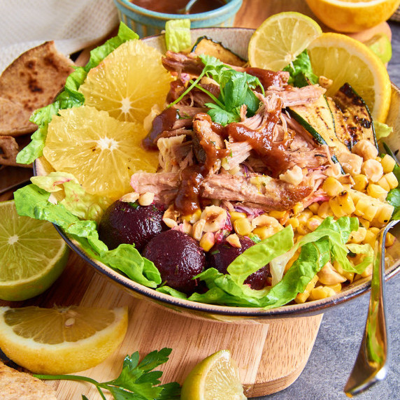 : A Bowl of Cuban Pulled Pork Salad. Topped with coleslaw, beets, charred sweetcorn, fried zucchini.